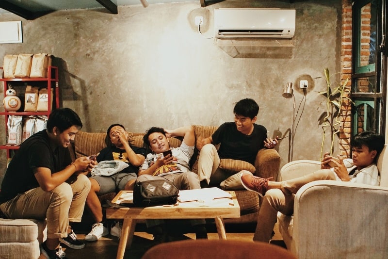 cinco hombres sentados en un sofá bajo techo