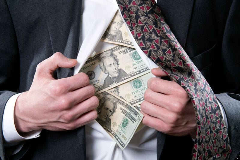 money bills inside the formal suit of a person trying to open