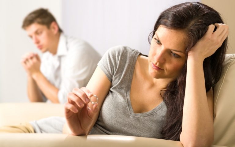Mulher triste com aliança de casamento na mão