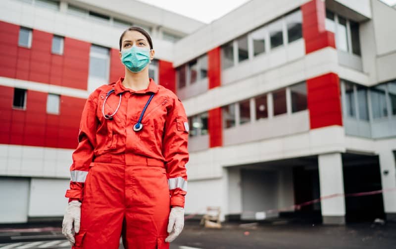 Nurse in front of hospital dressed up in red costume