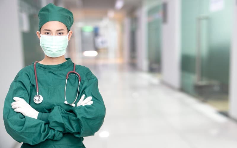 Enfermera con traje verde en el pasillo de un hospital