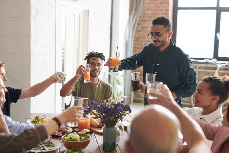 grupo de pessoas a fazer um brinde à mesa