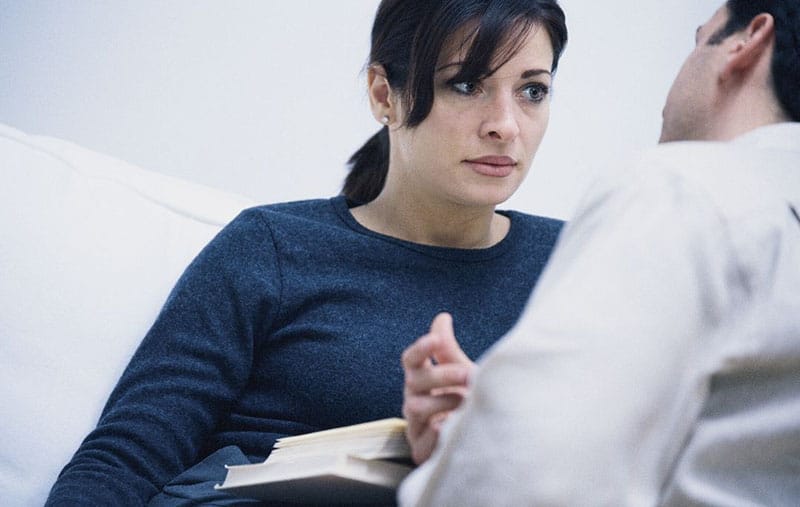 serious couple talking woman wearing a blue top 