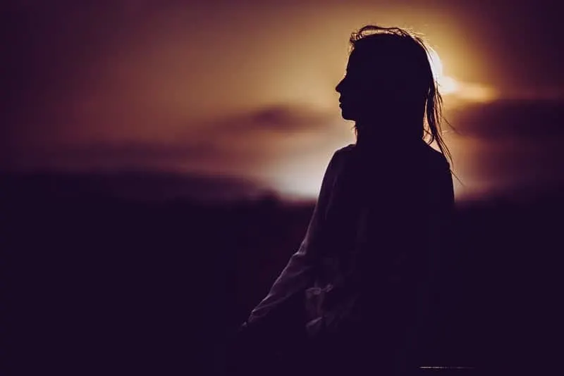 silhouette of person sitting during dusk/dawn