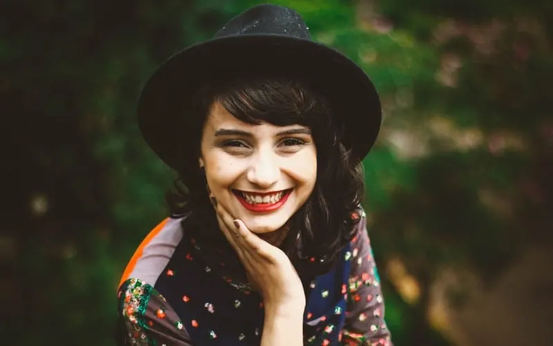Smiling young woman wearing black hat 