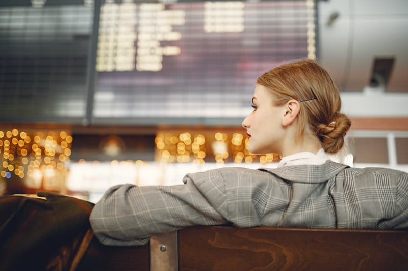 Giovane donna elegante che riposa nell'area di attesa di un aeroporto