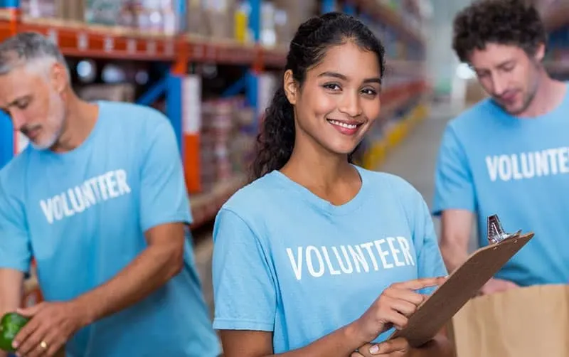 three persons volunteer in blue shirt with word volunteer
