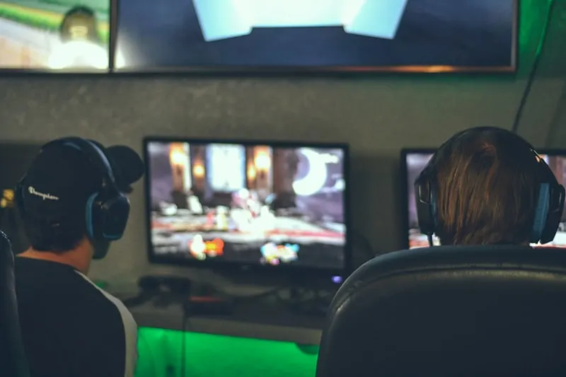  two persons playing game in front of monitors