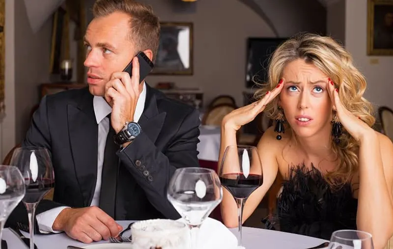 uncomfortable woman dating a guy busy with answering a call from the cellphone