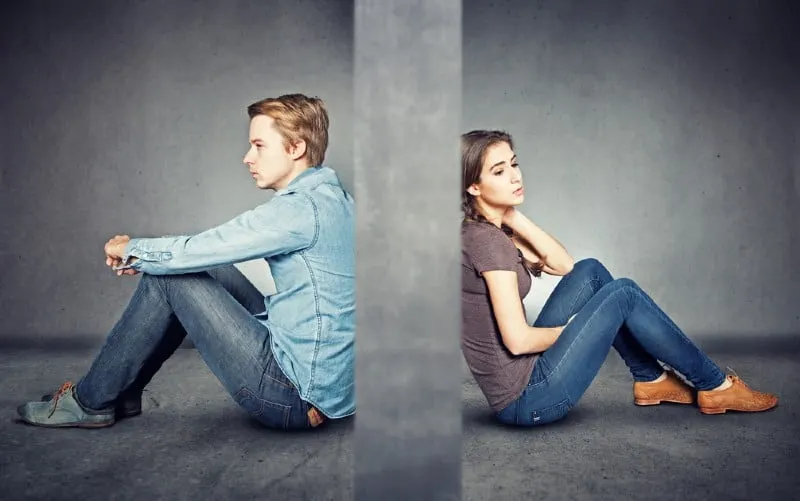 Grey wall between man and woman sitting on the floor