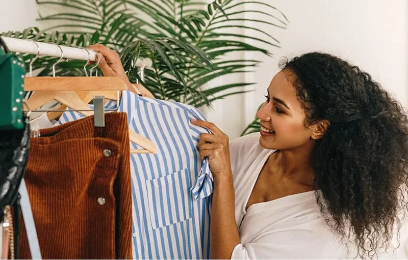 woman choosing dress in the clothes rack