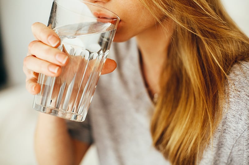 mujer bebiendo agua de un vaso