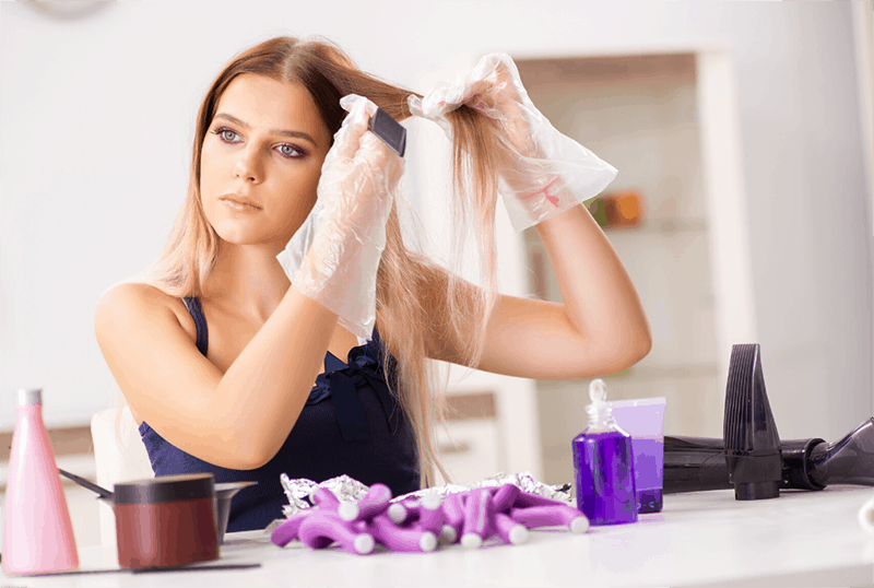 woman dyeing her hair with color purple dye on the table