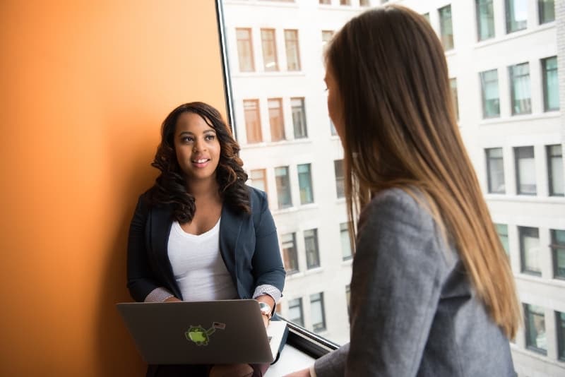 woman in black blazer holding laptop on lap