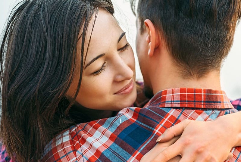 woman hugging a man in checkered in focus
