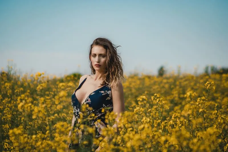 woman in floral dress standing in flower field