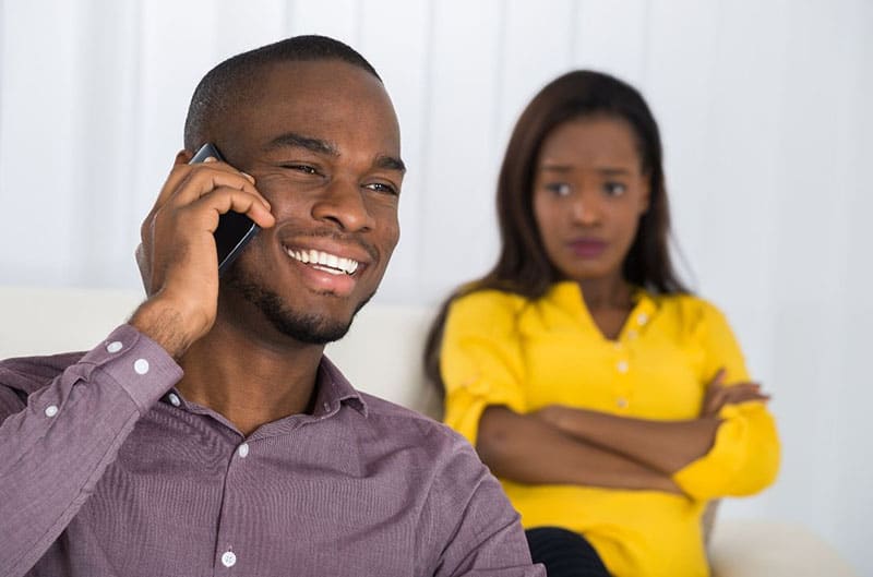 mulher a olhar para um homem que está a fazer uma chamada à distância para ela