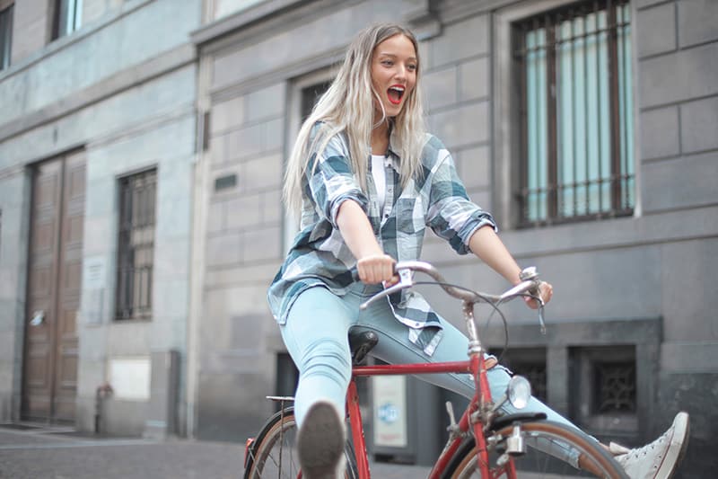 donna in bicicletta vicino a un edificio