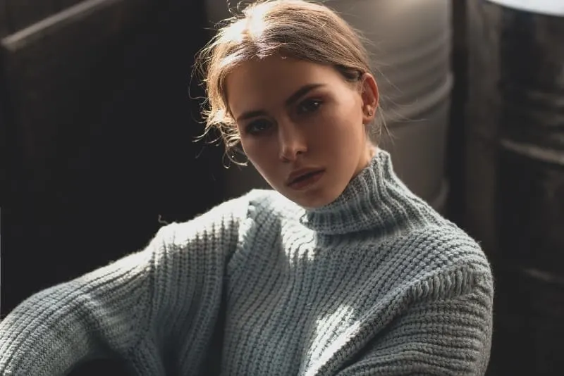 woman in gray sweater sitting indoor