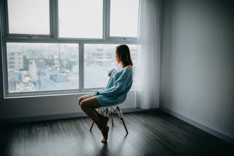 woman sitting on chair beside glass window
