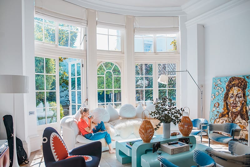 woman sitting on white couch near the window