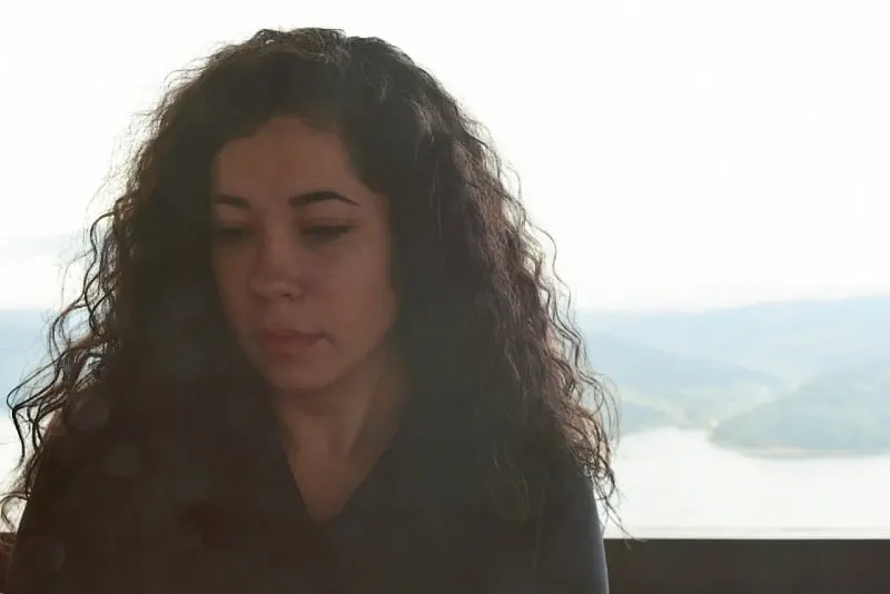 woman with curly hair sitting outdoor