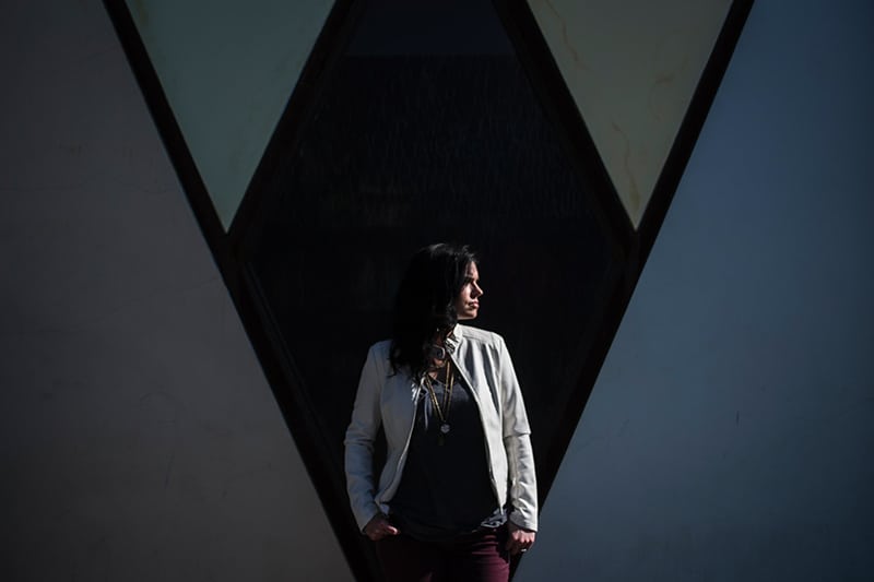 woman standing behind black wall while looking aside