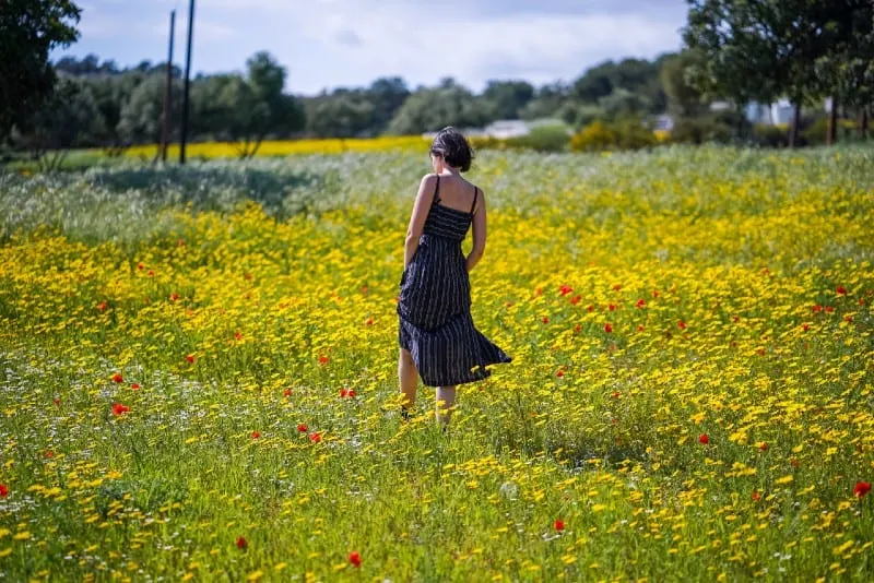 woman in long dress standing in flower field