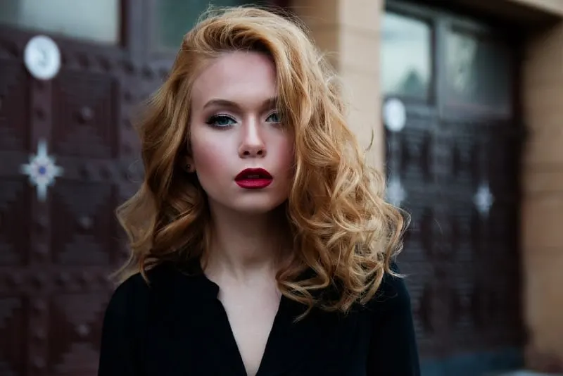 blonde woman with red lipstick standing outdoor