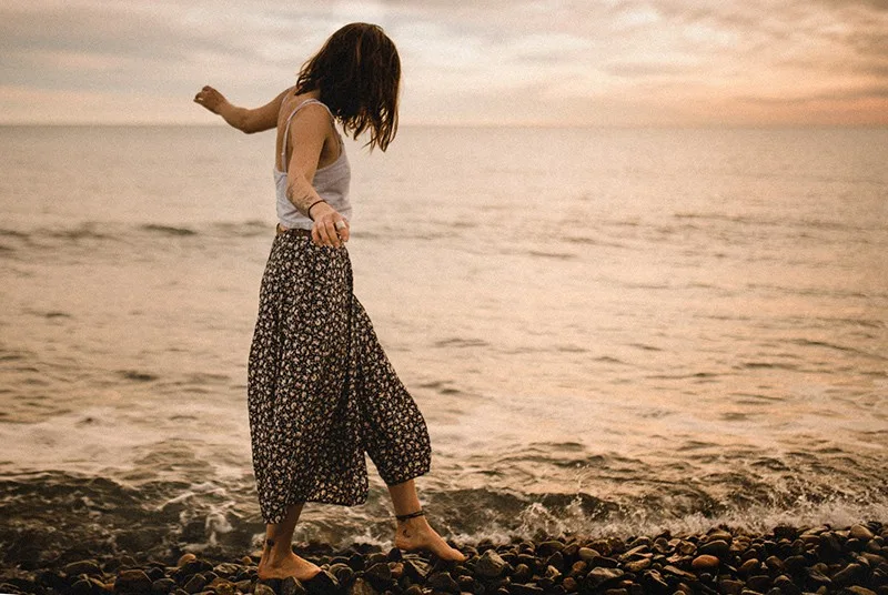 woman walking on rocks near the sea