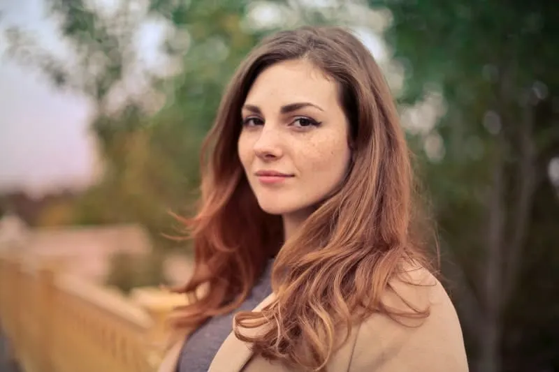woman with red hair wearing brown jacket