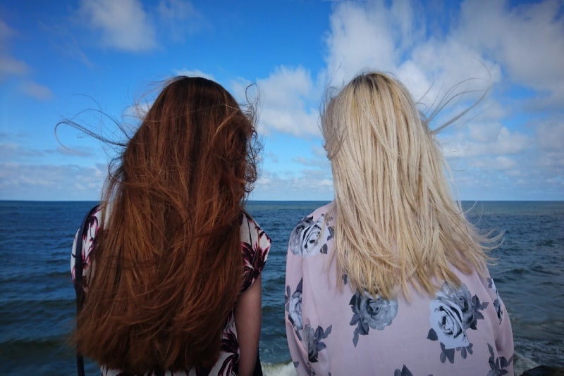 two women looking at sea during daytime