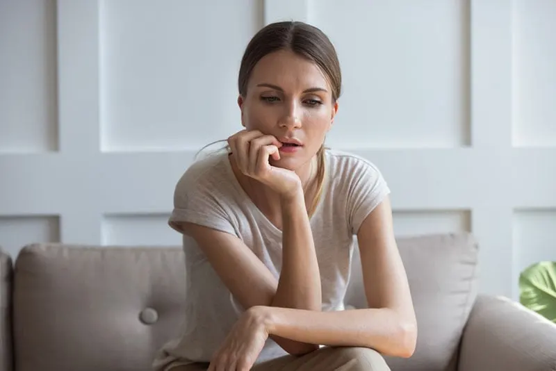 worried young woman sitting on the couch