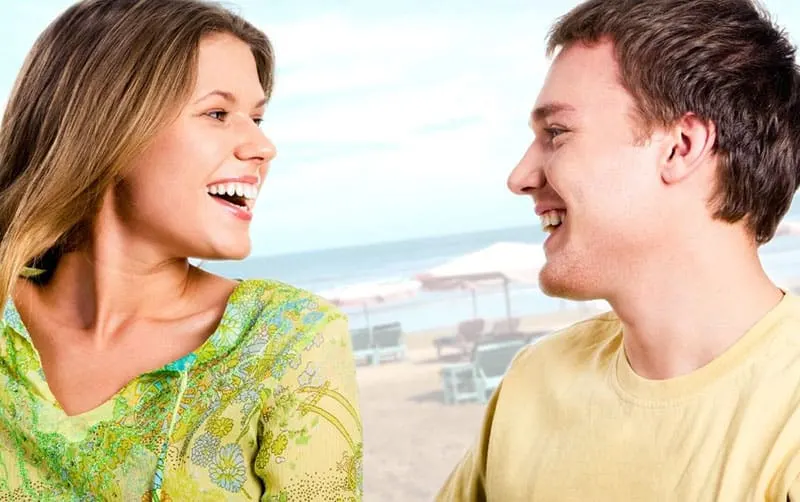 young couple speaking and laughing on the background of the sea