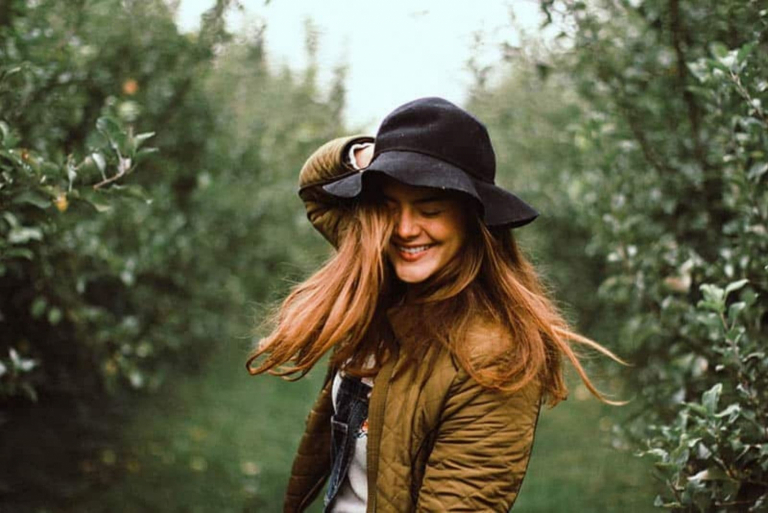 a woman with a hat on her head laughs