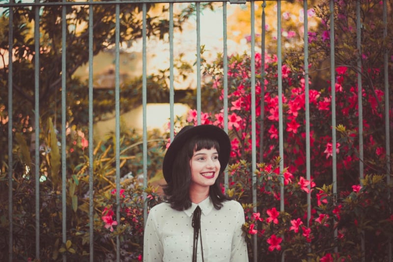 woman in white shirt standing near fence