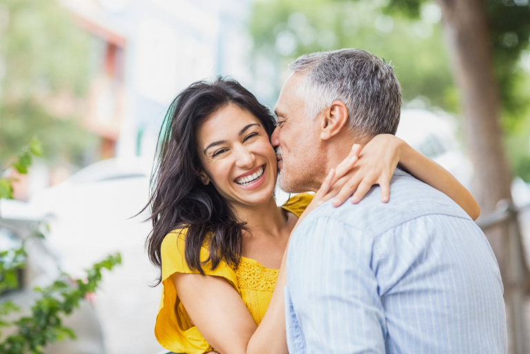 Man kissing cheerful woman