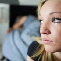 donna che piange faccia a fuoco fotografia con una persona addormentata in un lontano