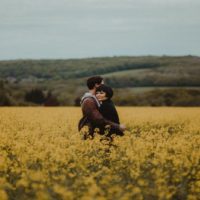 hombre y mujer abrazados en medio de un campo de flores