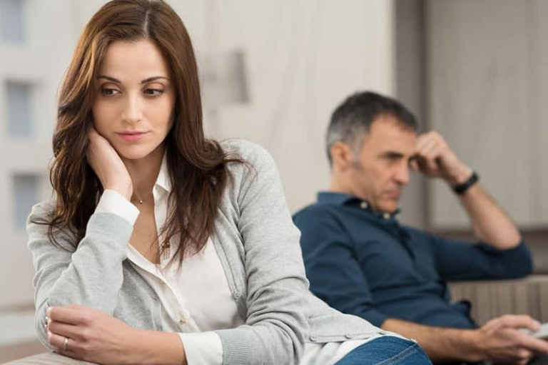 pensive woman distant a man watching tv