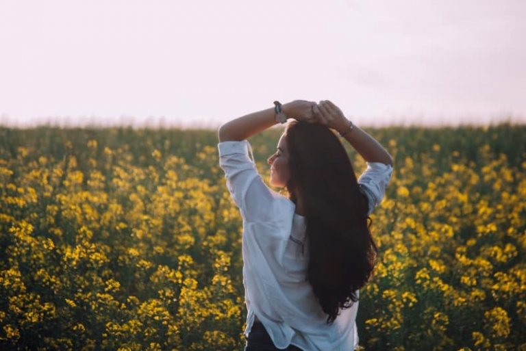 mujer de pie cerca de flores amarillas