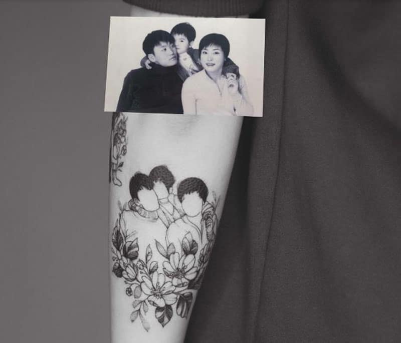 Tatuaggio con ritratto di famiglia inchiostrato sul braccio con una foto in alto