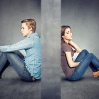 uomo e donna tristi seduti sul pavimento