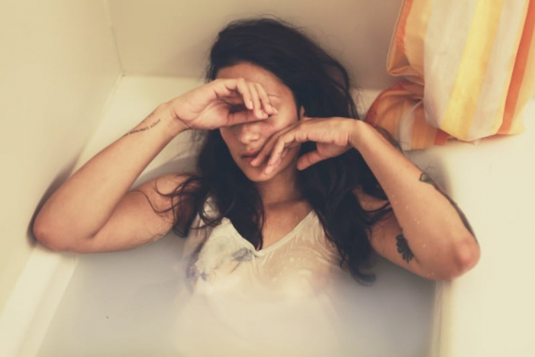 a woman in bathtub with clothes on