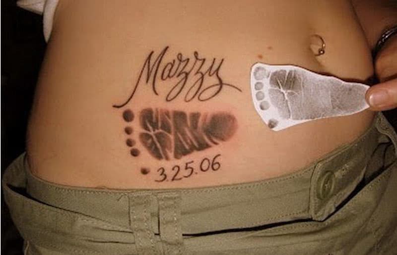 Tatuaggio personalizzato con impronta del piede del bambino inchiostrata sul lato della pancia