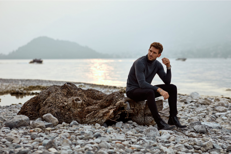 handsome man wearing sweater sitting outdoors alone
