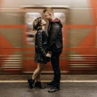 homem e mulher de mãos dadas numa plataforma de uma estação de comboios