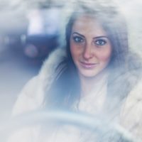 a portrait of a beautiful brunette driving a car