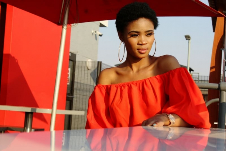 woman in red top sitting at table outdoor