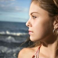 sideview of a pensive woman staring far near the sea